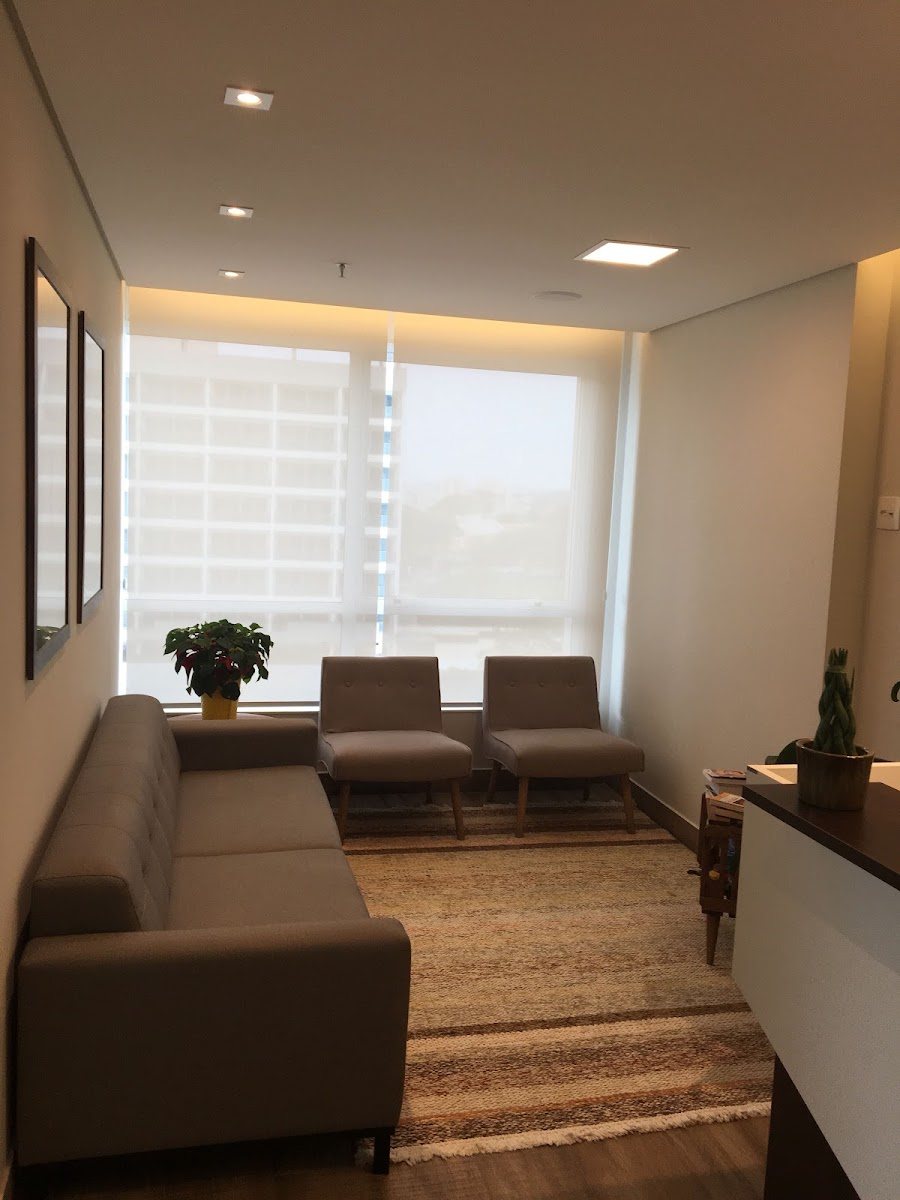 Sala de espera do consultório, com sofá e iluminação clara