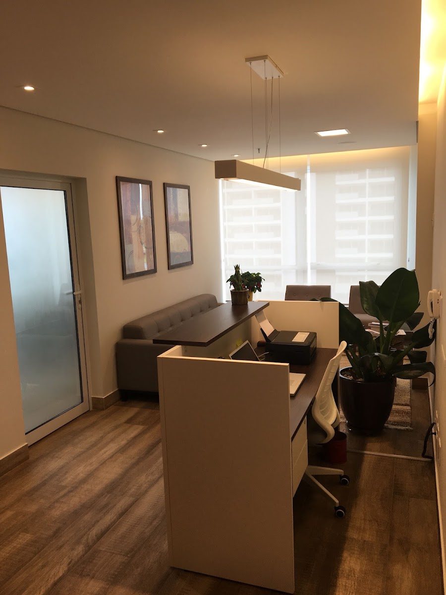 Ambiente interno do consultório, com plantas e janela com cortina